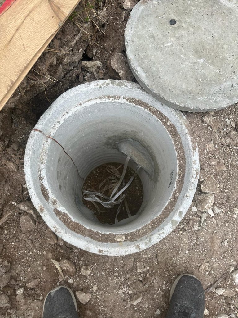 Open concrete underground manhole or utility vault.