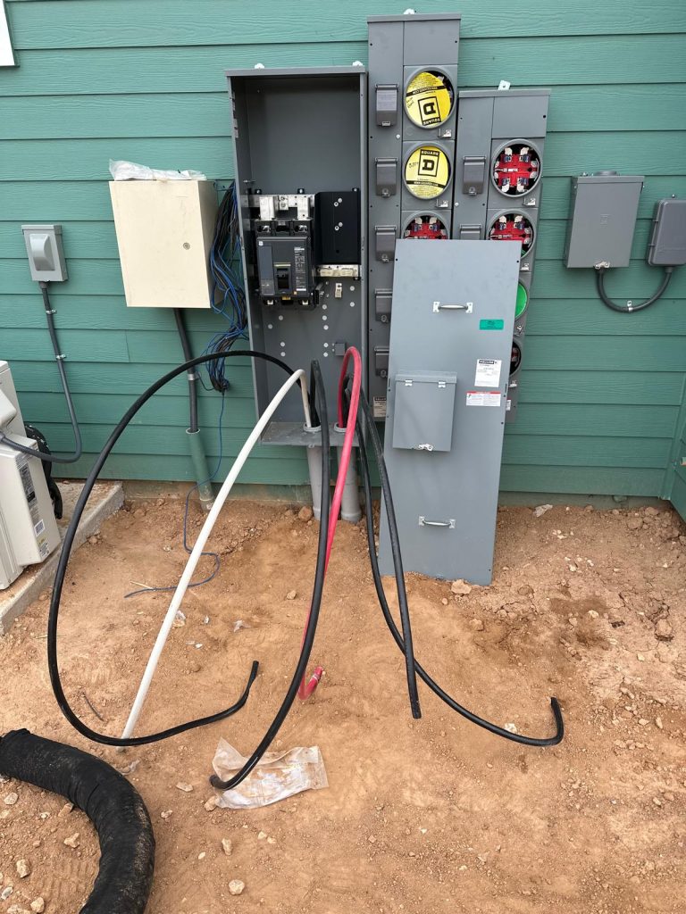 Electrical service installation with meter boxes, multiple panels, and various colored conduits.