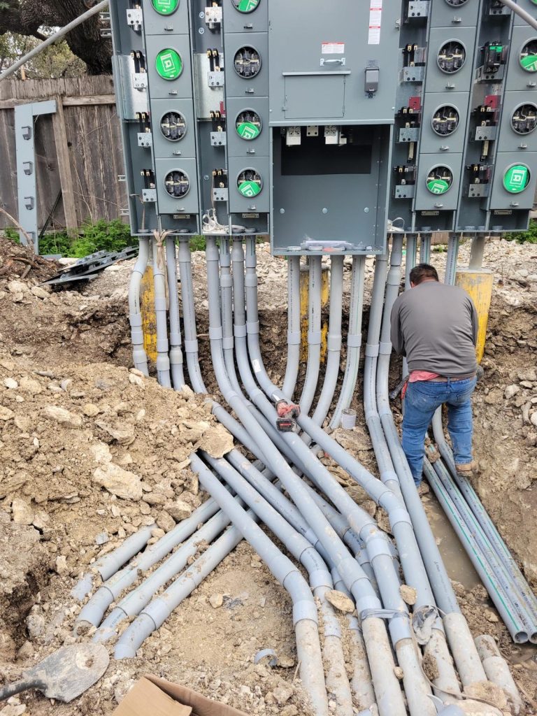 Construction worker installing multiple meters for an apartment complex.