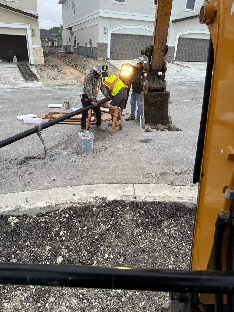 Construction workers holding a solar street light pole.