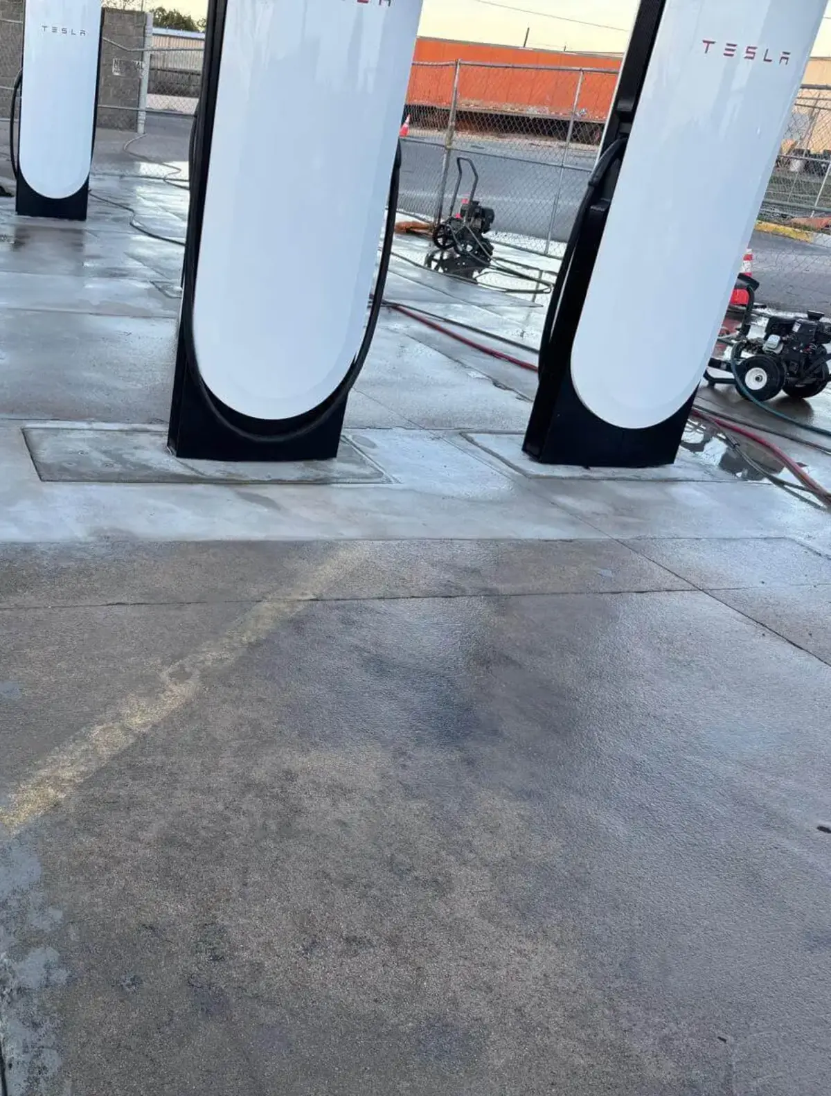Final site cleanup and pressure washing of concrete pads after Tesla Supercharger installation by Soga Underground.