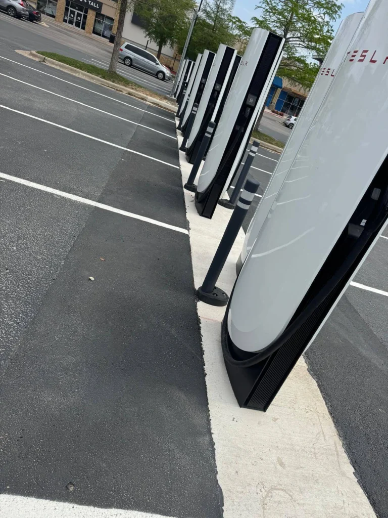 tesla charging stations installed with underground electrical infrastructure in commercial parking lot